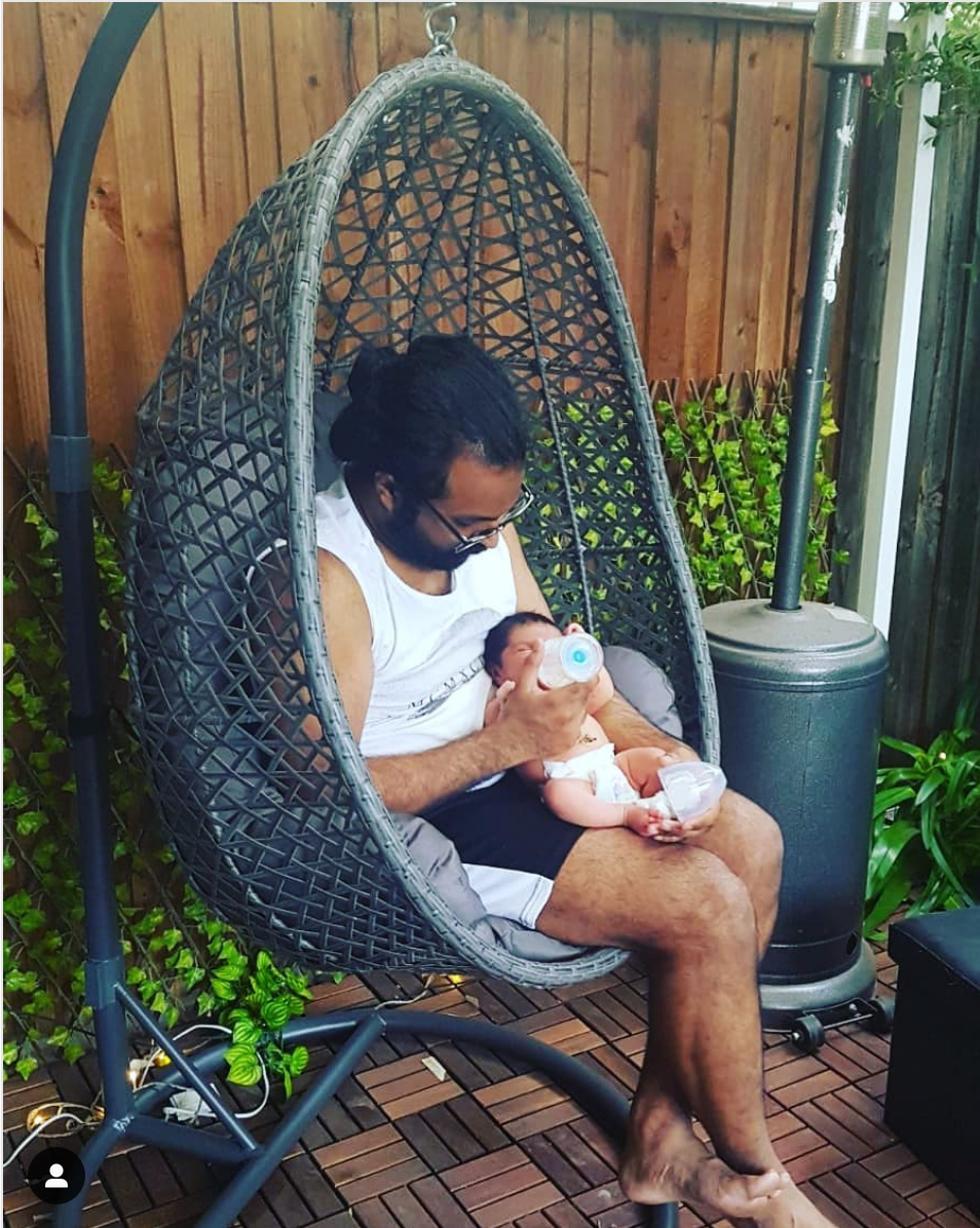 Man feeding a newborn milk from a bottle